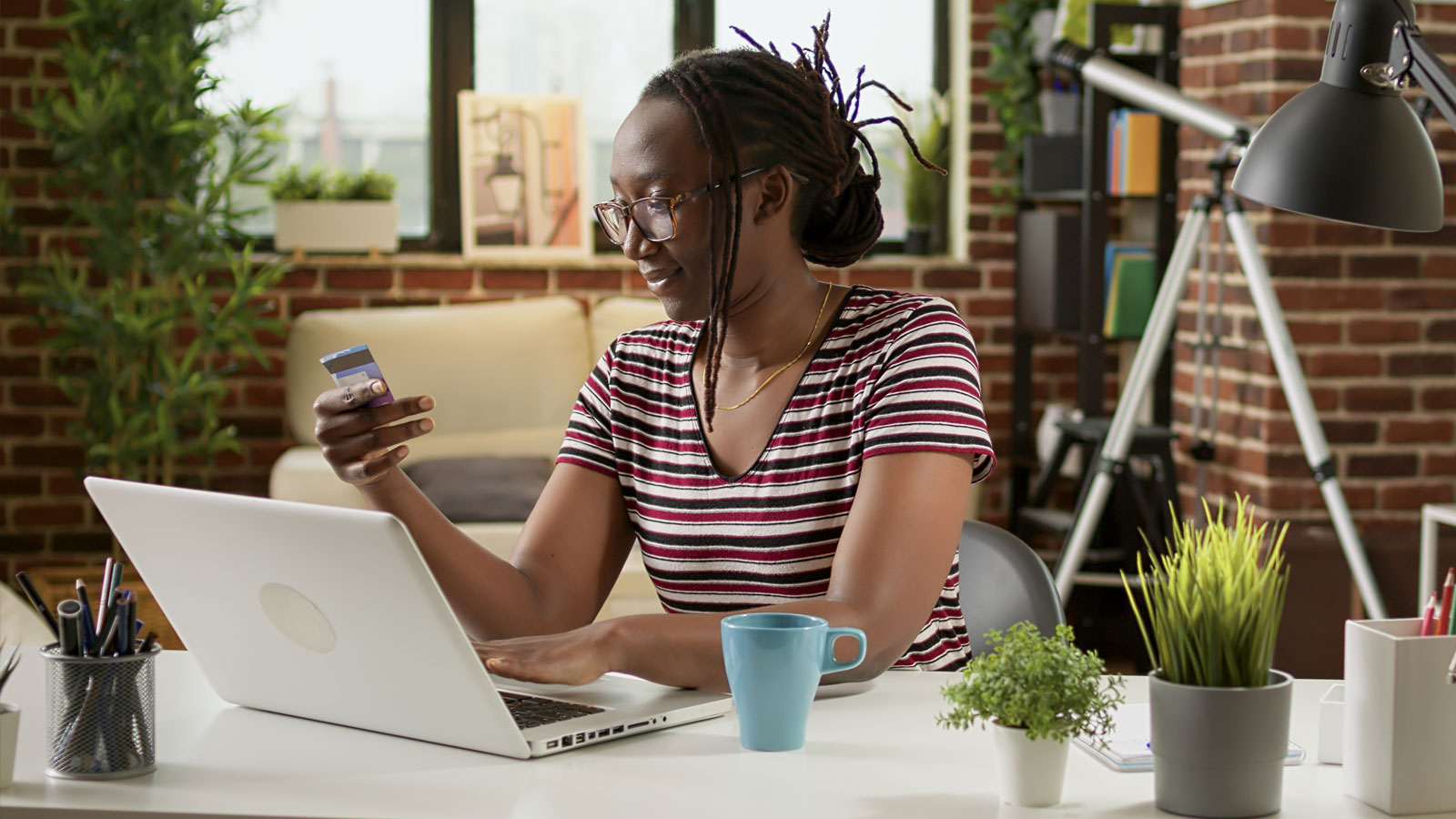 A woman checks her credit card while shopping online: small business website design